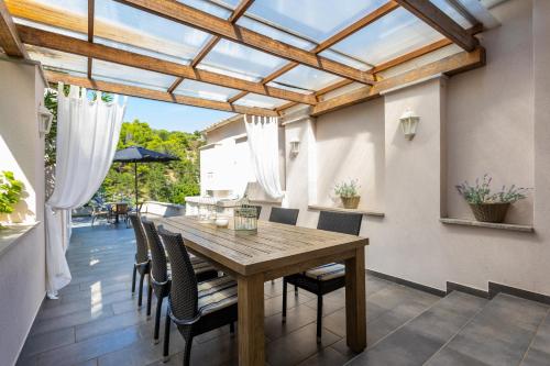 a dining room with a wooden table and chairs at Seafront Apartment With Amazing Seaview in Vrbnik