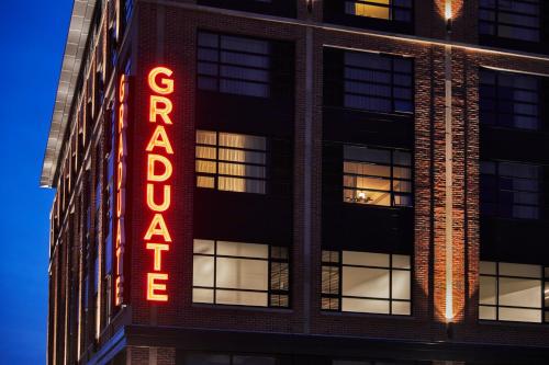 un bâtiment avec un panneau de néon sur son côté dans l'établissement Graduate Bloomington, à Bloomington