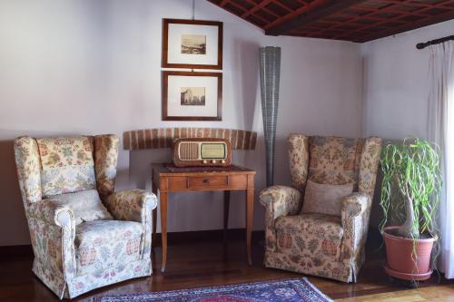 a living room with two chairs and an old radio at Palazzo Raspanti in Treviso