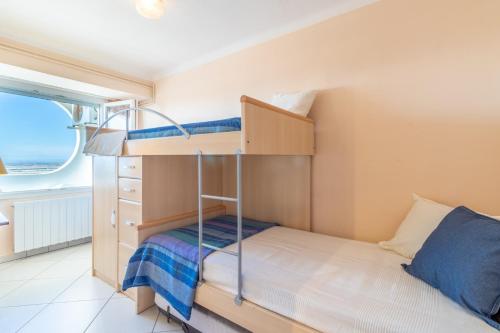エンプリアブラバにあるApartamento de dos habitaciones con vistas al marの小さなベッドルーム(二段ベッド1組、窓付)