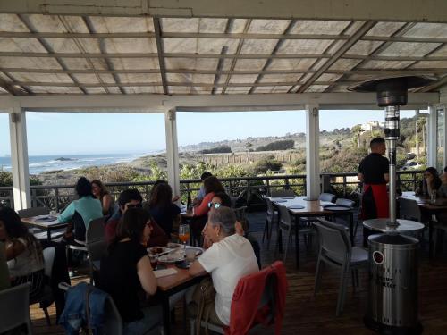 a group of people sitting at tables in a restaurant at B&B Santo Domingo Chile ENGLISH SPOKEN Gran Departamento compartido frente al mar PARQUE TRICAO bird sanctuary 14kms 9miles away DESAYUNO ESTACIONAMIENTO Y WIFI GRATIS Free parking wifi and breakfast in Santo Domingo