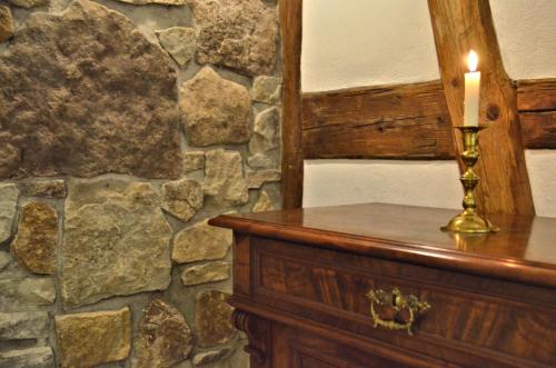 a candle sitting on top of a wooden table with a stone wall at Hotel & Café Mohrenbrunnen in Eisenberg