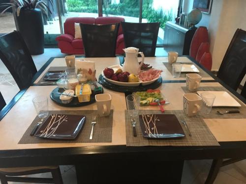 a dining room table with a plate of food on it at Casa la Selva in Cancún