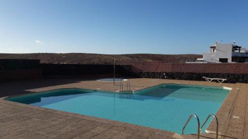 una grande piscina blu in cima a un tetto di Omae Papagayo a Playa Blanca