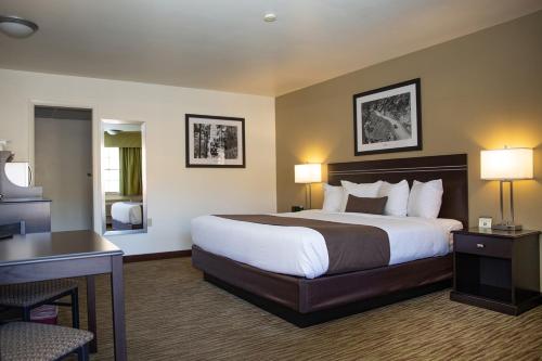 a hotel room with a large bed and a desk at Villa Motel at Manitou Springs in Manitou Springs