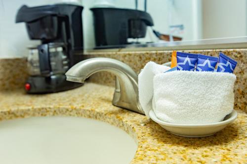 a sink with a bowl of toilet paper on a counter at Villa Motel at Manitou Springs in Manitou Springs