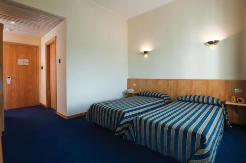 um quarto de hotel com duas camas com riscas azuis e brancas em La Fonte dell'Astore em Castelpetroso