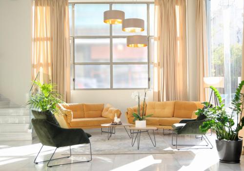 a living room with a couch and chairs and a table at B4B Athens Signature Hotel in Athens