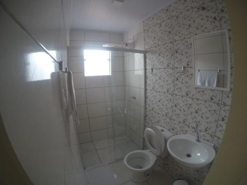 a bathroom with a toilet and a sink at Hotel Blumenpark in Rio Negro