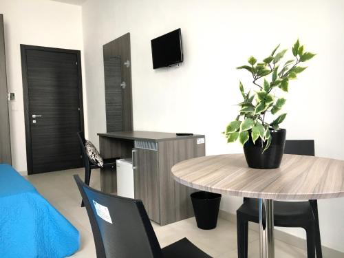 a living room with a table and a potted plant at B&B Costa Azzurra in Porto Cesareo