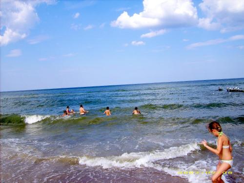 a group of people in the water at the beach at Słoneczny Zakątek in Sarbinowo