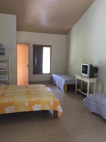a hotel room with two beds and a television at Espaço Smidt in Santa Branca