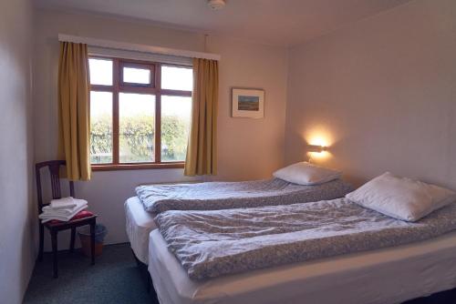 um quarto de hotel com duas camas e uma janela em Solvanes Farmholidays em Varmahlid
