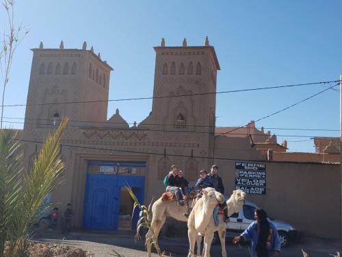 a group of people riding horses in front of a building at Gite Kasbah La Palmeraie in Skoura