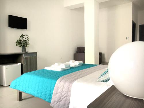 a bedroom with a bed with a blue blanket at B&B Costa Azzurra in Porto Cesareo