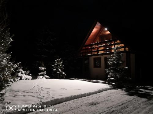 a house in the snow at night at Chata pod pilskom in Sihelné