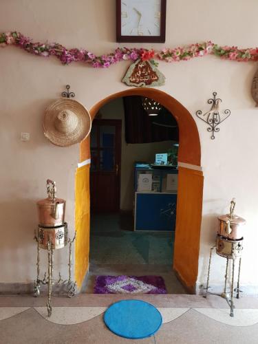 a room with an arch with a clock on the wall at Gite Kasbah La Palmeraie in Skoura
