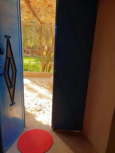 an open door to a room with a red rug at Gite Kasbah La Palmeraie in Skoura