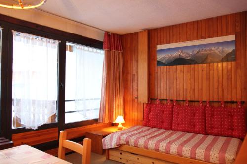 a bedroom with a bed and a window with mountains at Neves in Val Thorens
