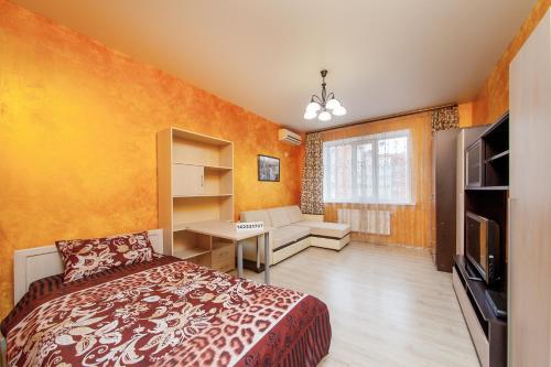 クラスノダールにあるPanorama apartments 28のオレンジ色の壁のベッドルーム1室、ベッド1台が備わります。