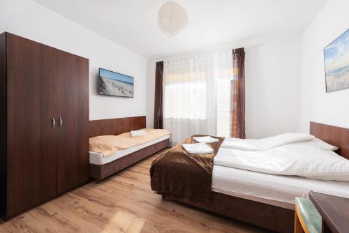 1 dormitorio con 2 camas y ventana en FajnePokoje - ANTEK, en Władysławowo