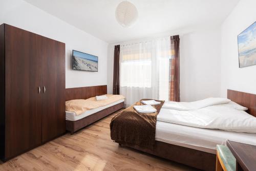 una camera da letto con due letti e una finestra di FajnePokoje - ANTEK a Władysławowo
