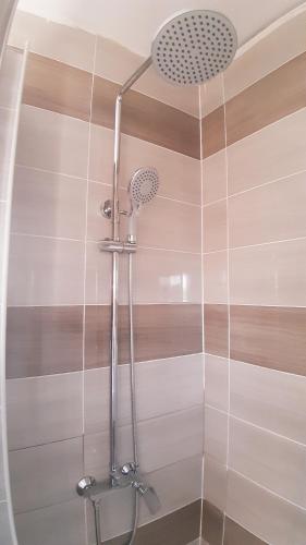 een douche met een douchekop in de badkamer bij Rooms & Apartments Amelee in Zagreb