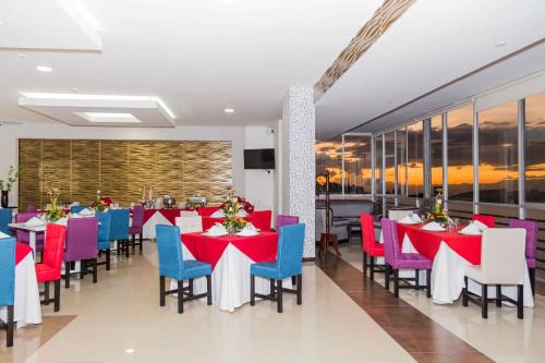 un comedor con mesas y sillas rojas y azules en Hotel Varuna, en Manizales