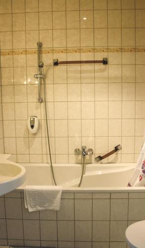 a bathroom with a tub and a toilet and a sink at Hotel Heidekrug in Grünplan