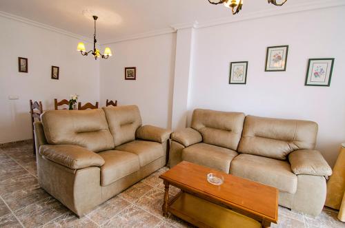 a living room with two couches and a coffee table at Aptº ATALAYA , cerca de la Playa in Conil de la Frontera
