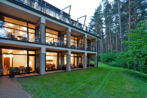 an exterior view of a house with a yard at Belvilis Hotel in Molėtai