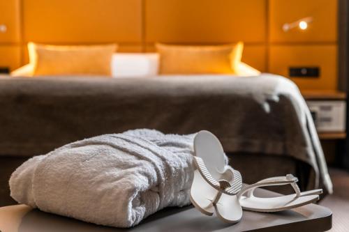 a pair of sandals and a towel on a bed at Hotel Residence Europe & Spa in Clichy