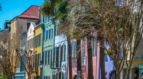 a row of colorful buildings on a street with palm trees at Cambria Hotel Mount Pleasant - Charleston in Charleston