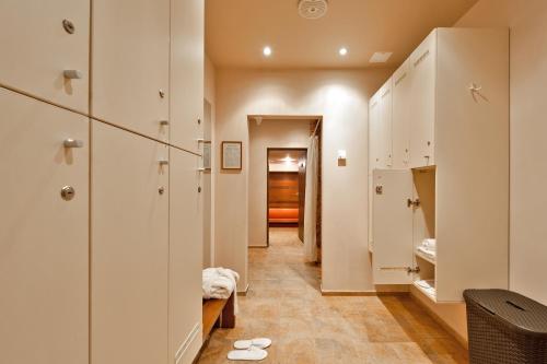 a hallway with white cabinets and shoes on the floor at Belvilis Hotel in Molėtai