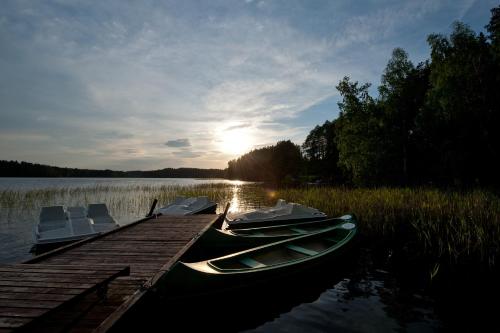 two boats are docked at a dock on a lake at Belvilis Hotel in Molėtai