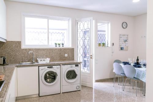 a white kitchen with a washing machine and a sink at Je T'aime Matosinhos Beach in Matosinhos