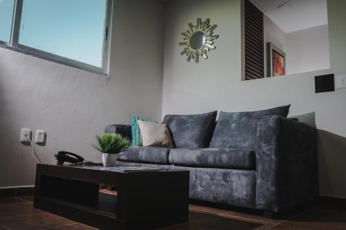a living room with a leather couch and a table at HOTEL CAREYES in Coatzacoalcos