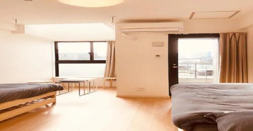 1 Schlafzimmer mit 2 Betten, einem Tisch und einem Fenster in der Unterkunft ENZO / Vacation STAY 13251 in Fukuoka
