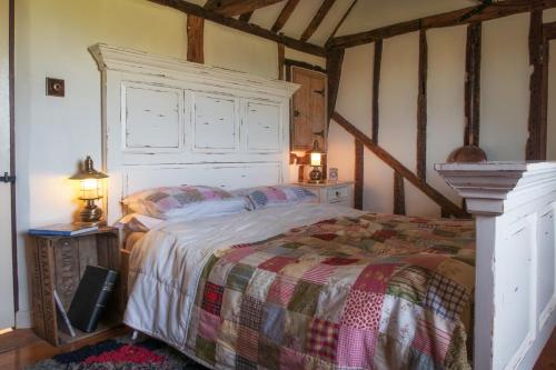 a bedroom with a large bed in a room at Coldharbour Cottage with Hot Tub in Stone