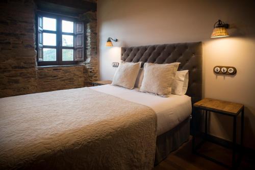 a bedroom with a large bed and a window at Aldea Rural y Gastro Restaurante Casona de Labrada in Labrada