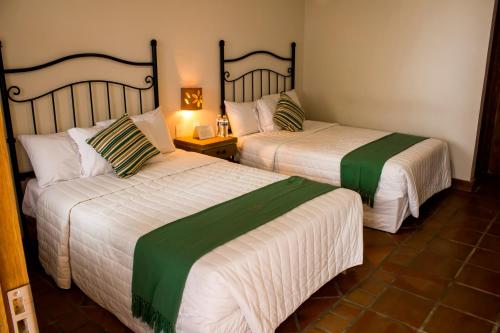 two beds in a hotel room withacersacers at Puerta San Pedro in Guadalajara