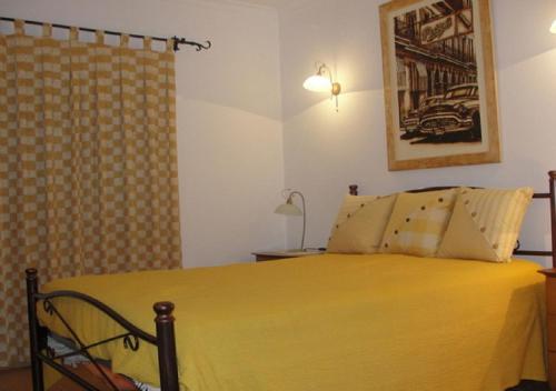 ein Schlafzimmer mit einem gelben Bett und einer Dusche in der Unterkunft Vivenda V3 Praia Verde in Castro Marim