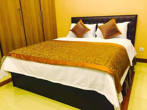 a large bed in a hotel room at Hayyat Luxury Hotel Apartments in Lahore