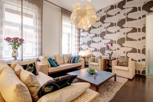 een woonkamer met een bank, stoelen en een tafel bij Downtown Residences in Boedapest
