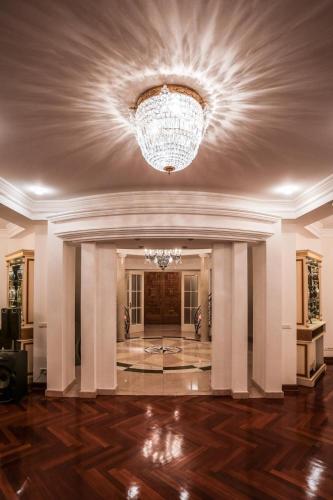a large lobby with a chandelier and wood floors at Villa Dedinje in Belgrade