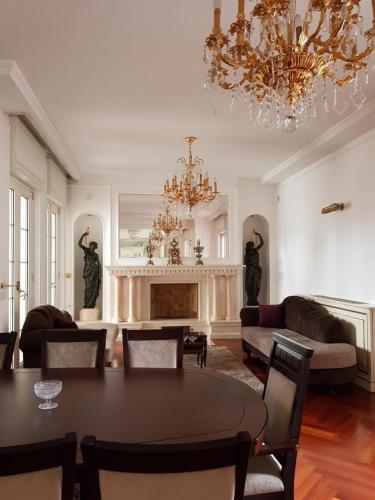 a living room with a table and a chandelier at Villa Dedinje in Belgrade