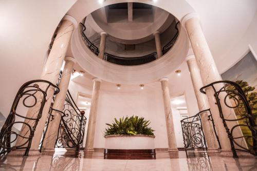 a spiral staircase in a building with chairs and a plant at Villa Dedinje in Belgrade