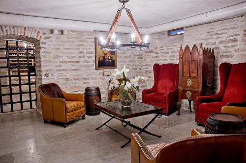 a living room with red chairs and a table at Schloss Fall, Keila-Joa in Keila-Joa