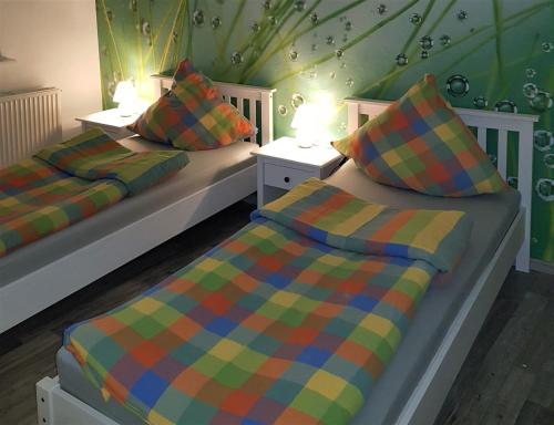 - 2 lits jumeaux dans une chambre aux murs verts dans l'établissement Ferienwohnung Pfitzmann, à Flensbourg