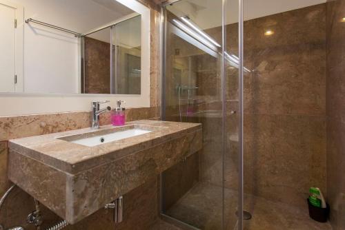 ein Bad mit einem Waschbecken und einer Dusche in der Unterkunft Exquisit Flat Right in Lissabon